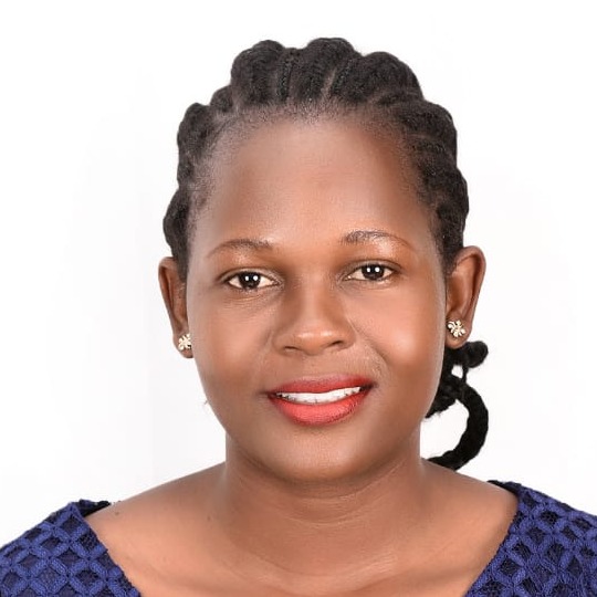 Portrait of a smiling woman with braided hair in a blue top, looking at the camera.